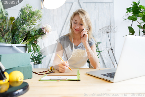 Image of Young florist talking on phone