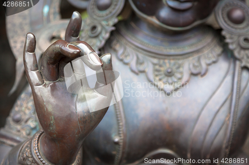 Image of Detail of Buddha statue with Karana mudra hand position