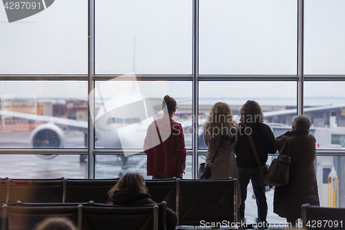 Image of People waiting for airplane departure on a rainy day.