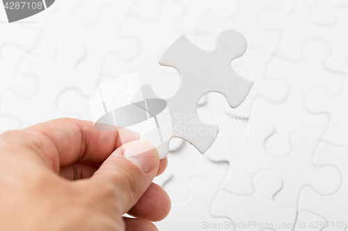 Image of Hand holding puzzle piece