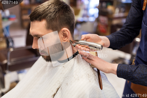 Image of man and barber hands with trimmer cutting hair