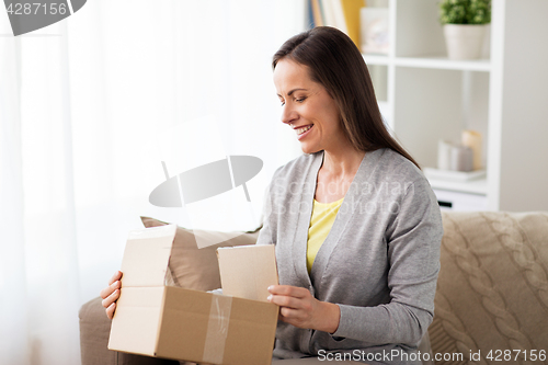 Image of smiling woman opening cardboard box