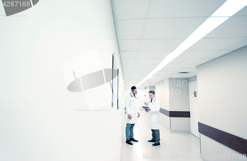 Image of male doctors with clipboard at hospital corridor