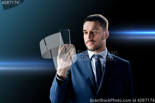 Image of businessman with transparent smartphone