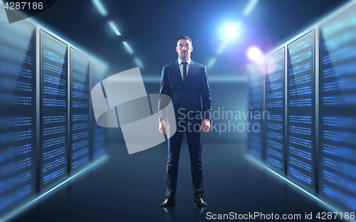 Image of businessman over server room background