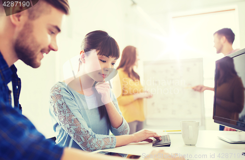 Image of creative team with blueprint at office