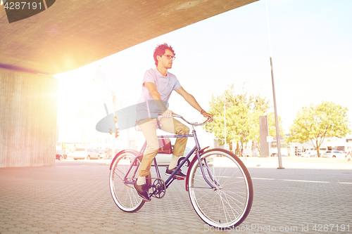 Image of young hipster man riding fixed gear bike