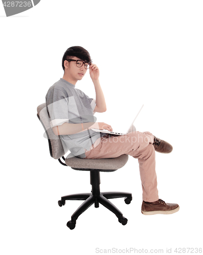 Image of Asian man typing at his laptop.