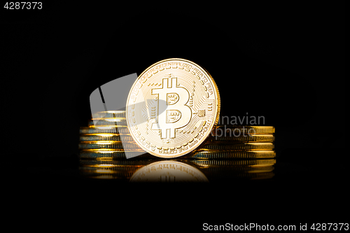 Image of Stack of golden Bitcoin coins on a black background