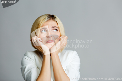 Image of Model with hand at chin on empty gray background