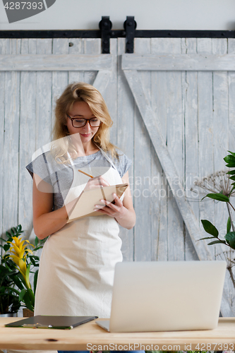 Image of Blond florist with glasses ,apron