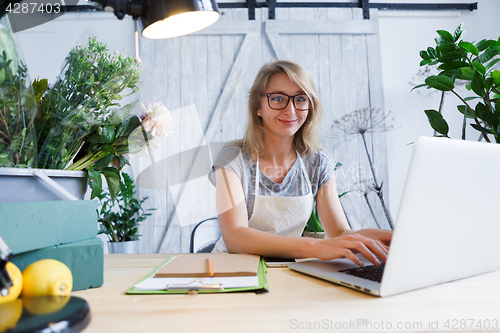 Image of Blonde florist sitting at table