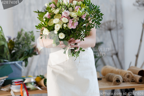 Image of Florist in apron with bouquet