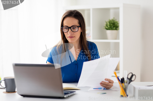 Image of happy woman with laptop working at home or office