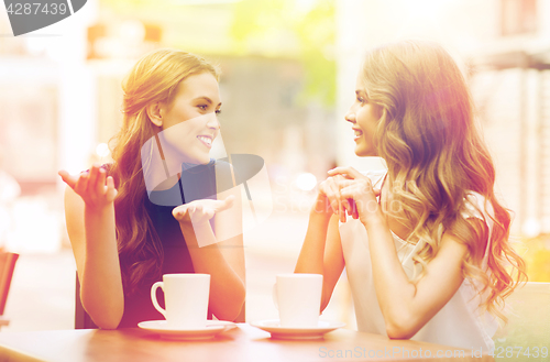 Image of young women drinking coffee and talking at cafe