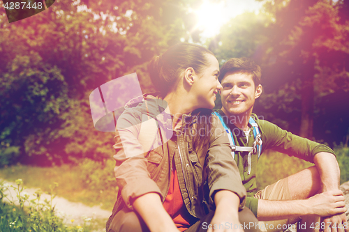 Image of smiling couple with backpacks in nature