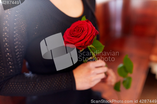 Image of close up of woman with roses at funeral in church