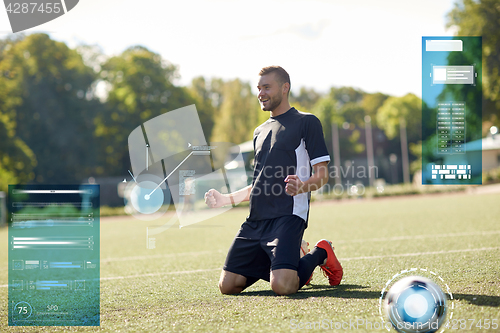 Image of happy soccer player with ball on football field