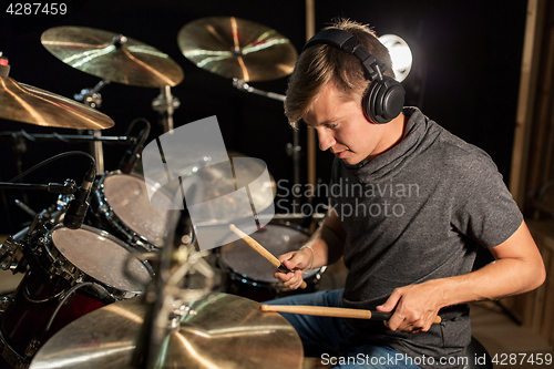 Image of male musician playing drums and cymbals at concert