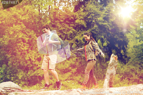 Image of happy couple with backpacks hiking outdoors