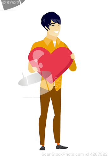 Image of Asian business man holding a big red heart.