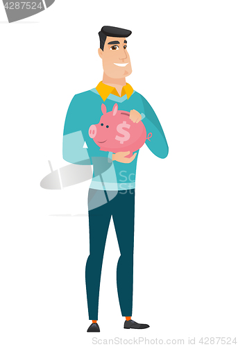 Image of Caucasian business man holding a piggy bank.