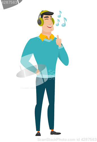 Image of Businessman listening to music in headphones.