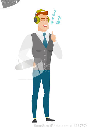 Image of Businessman listening to music in headphones.