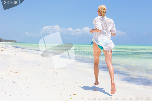 Image of Happy woman having fun, enjoying summer, running joyfully on tropical beach.