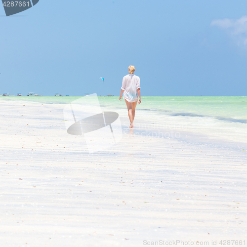 Image of Happy woman having fun, enjoying summer, running along white tropical beach.