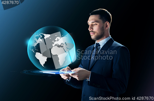 Image of businessman with tablet pc and earth projection