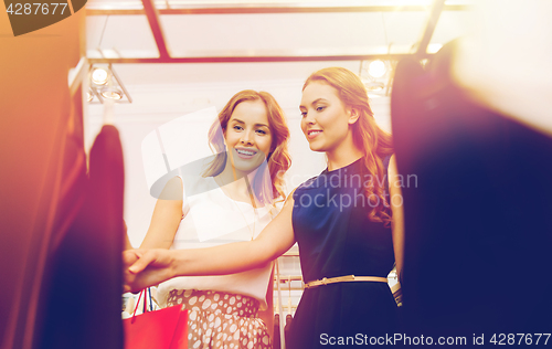 Image of happy women with shopping bags at clothing shop