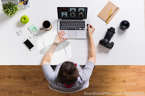 Image of woman with camera flash drive and laptop at table