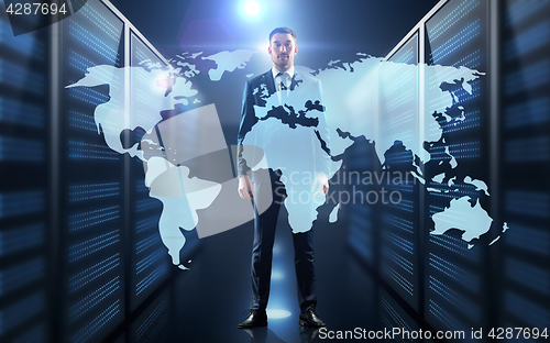 Image of businessman with world map projection in corridor