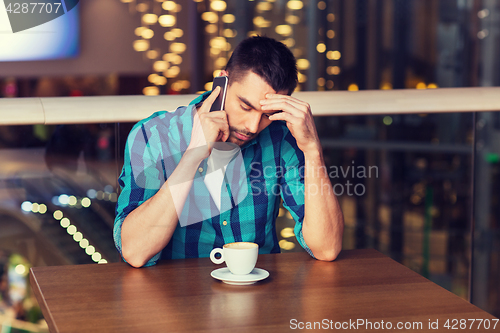 Image of man with smartphone and coffee at restaurant