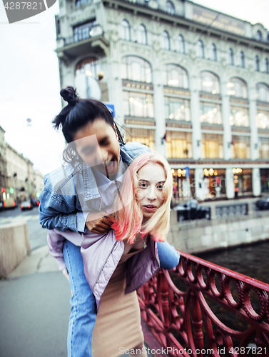 Image of Two teenage girls infront of university building smiling, having