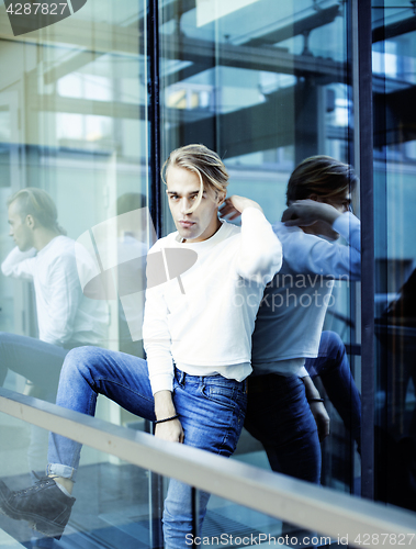 Image of young modern hipster guy at new building university blond fashion hairstyle having fun, lifestyle people concept 