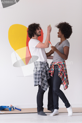 Image of couple with painted heart on wall