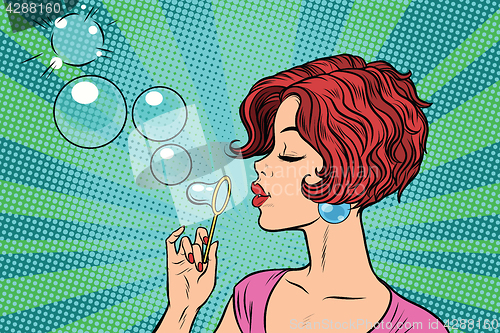 Image of Young woman blowing bubbles