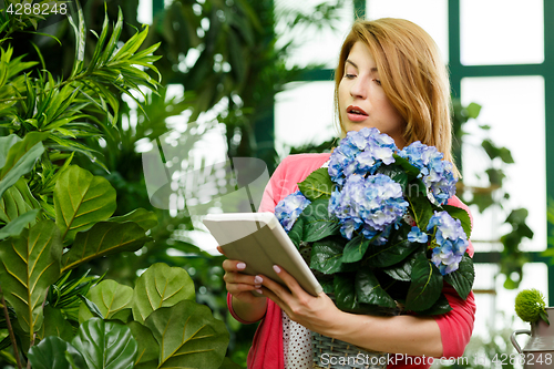 Image of Woman with bouquet holding tablet