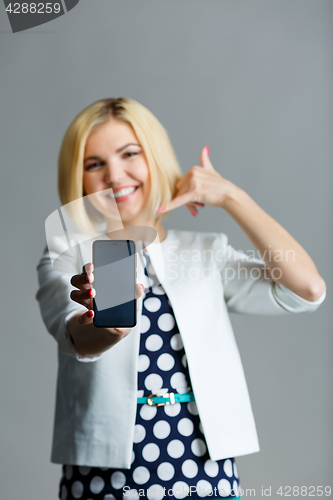 Image of Woman with phone showing shaka