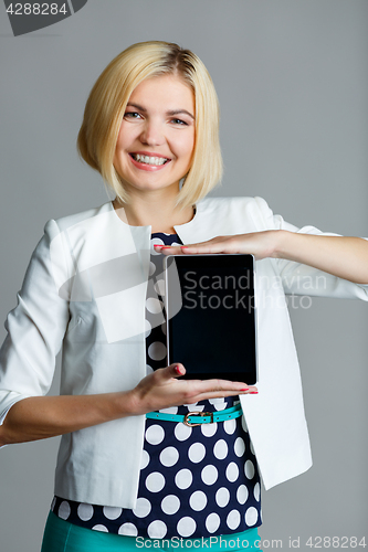 Image of Smiling young girl holding tablet