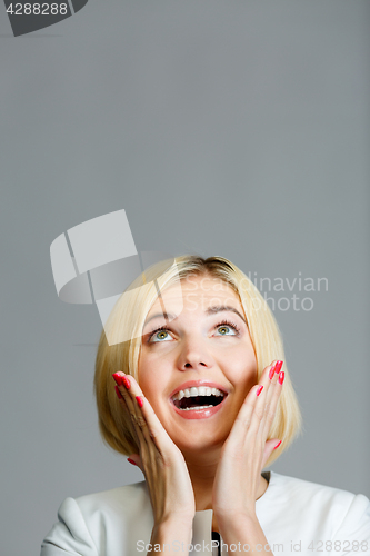 Image of Surprised happy woman looking up