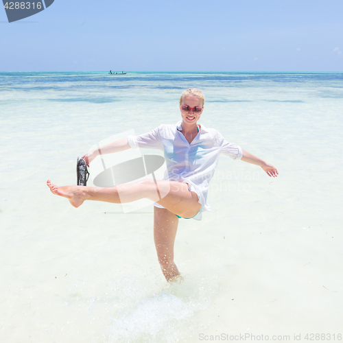 Image of Young active woman having fun on vacations in shellow sea water.