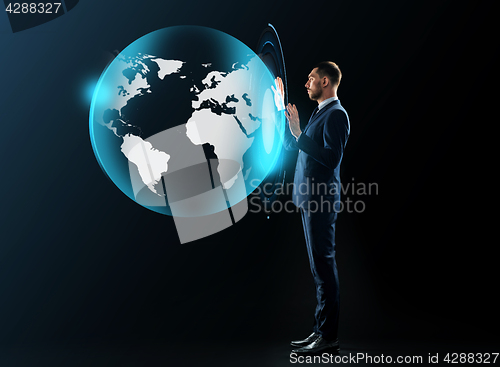 Image of businessman in suit with virtual earth projection