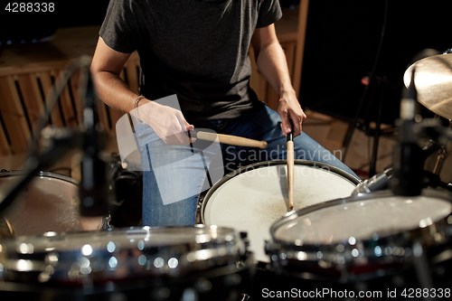 Image of man playing drums at concert or music studio