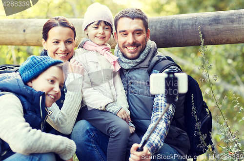 Image of happy family with smartphone selfie stick in woods