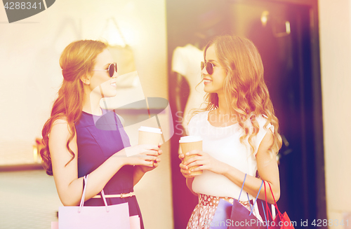 Image of young women with shopping bags and coffee at shop