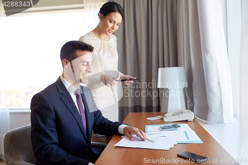 Image of business team with papers working at hotel room