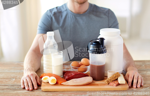 Image of close up of man with food rich in protein on table